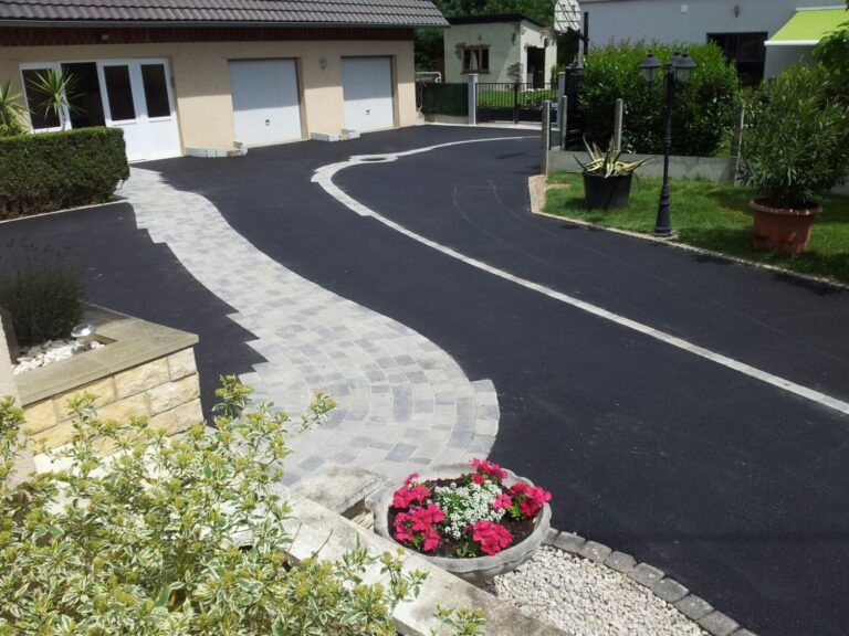 Allée en enrobé bordée de pavés devant une maison