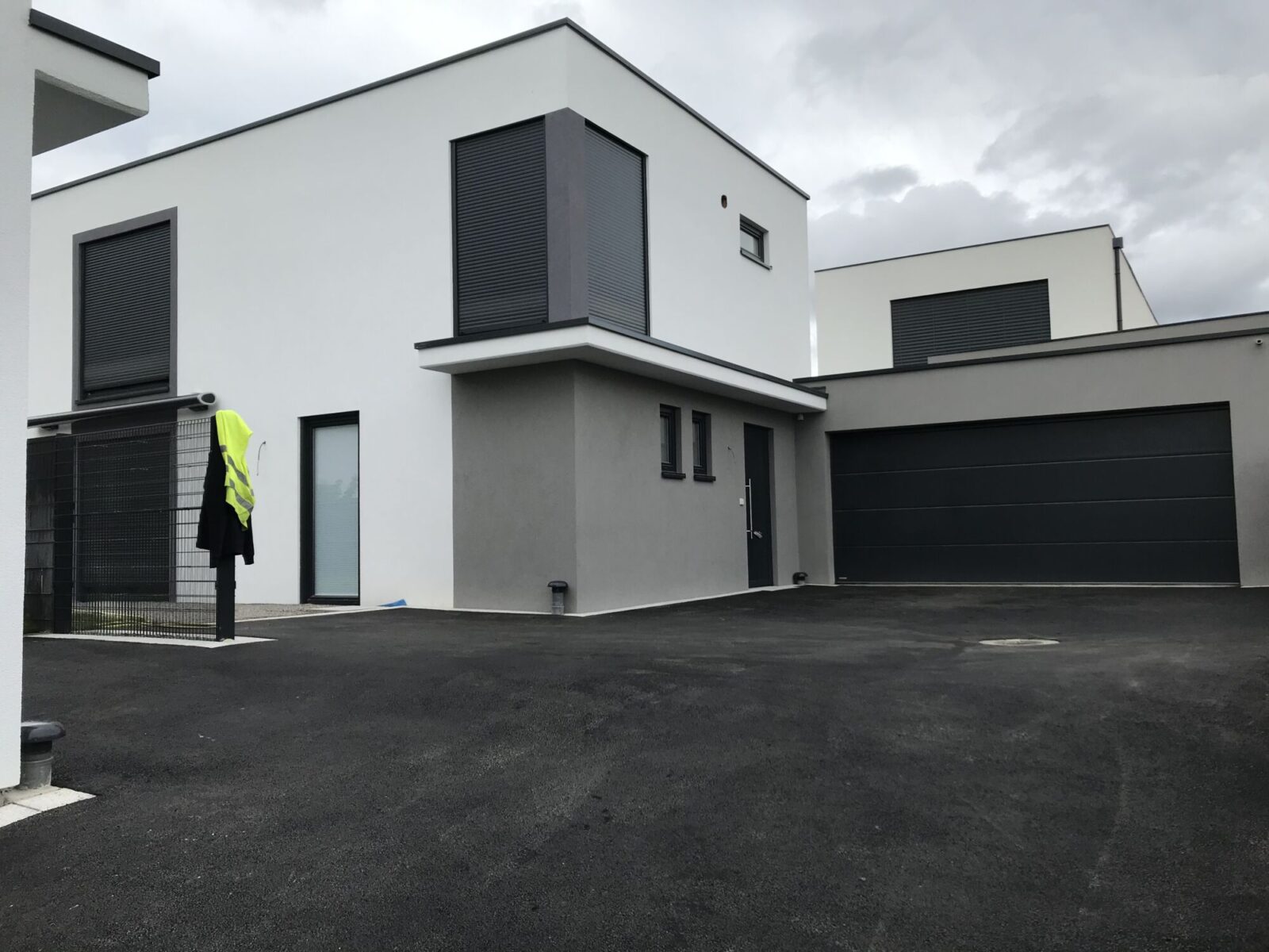 Cour en enrobé devant une maison contemporaine