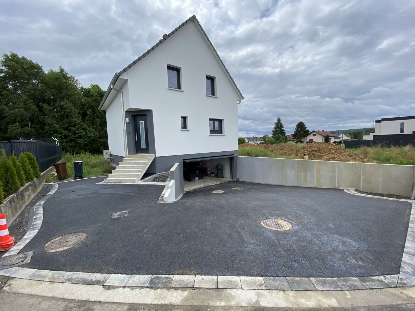 Cour en enrobé devant une maison neuve