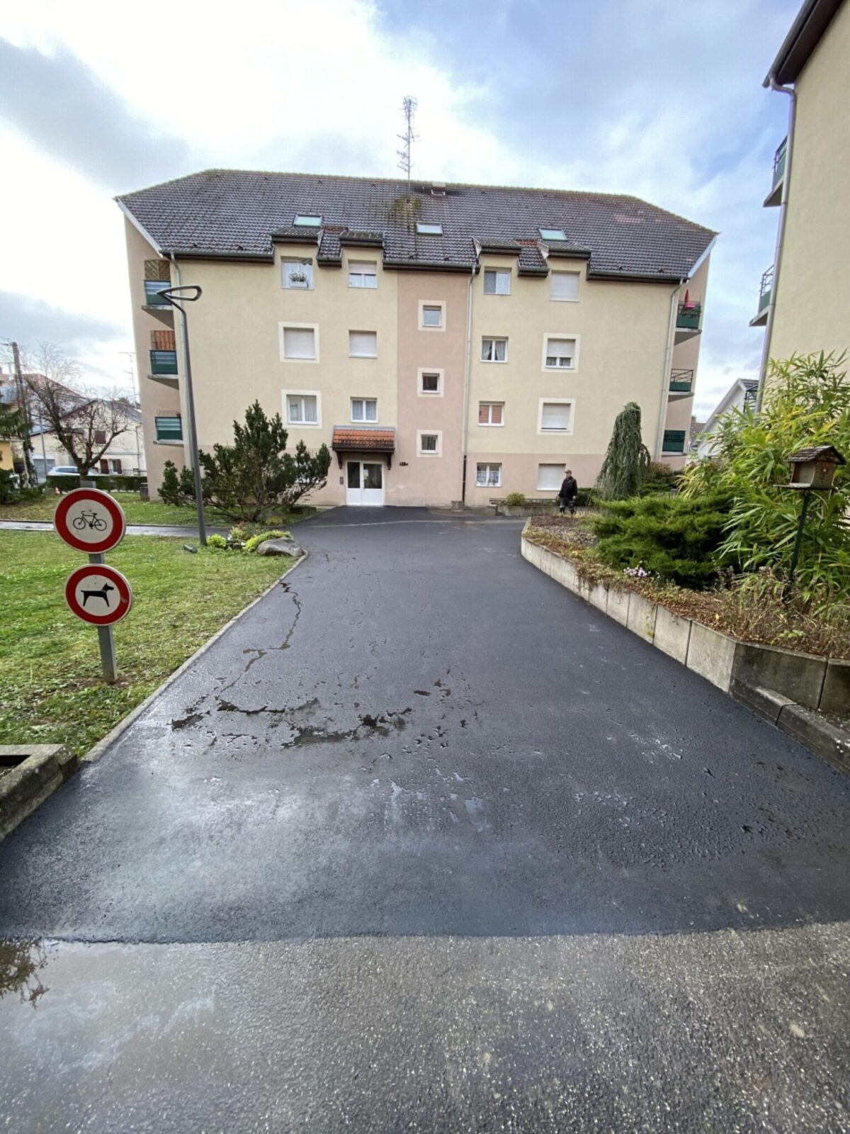 Voie d’accès en enrobé devant un immeuble