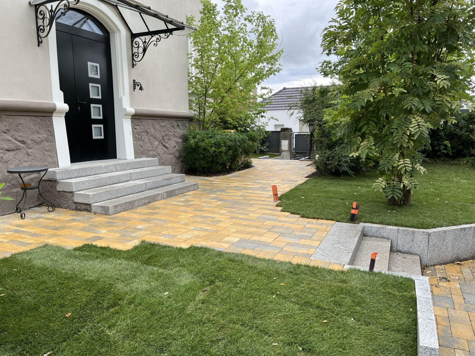 Escalier, dallage et pelouse devant une maison
