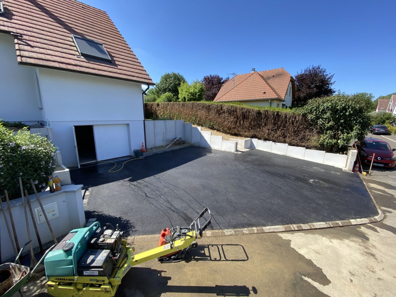 Cour en enrobé devant une maison